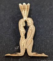 Close-up image of the pendant showing the detailed design of the kneeling couple from the front.