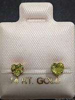 Front view of the pair of heart-shaped peridot stud earrings set in 14K gold.