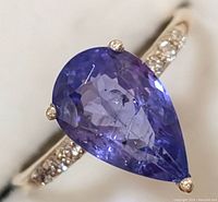 Close-up view of pear-shaped tanzanite with diamond-set shoulders