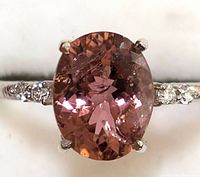 Close-up of oval pink tourmaline center stone and diamond-set shoulders
