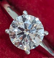 Close-up front view of round brilliant diamond solitaire in four-prong setting on white gold band