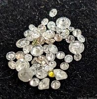 Assorted loose diamonds on black felt background