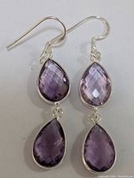 Front view of the pair of silver amethyst drop earrings showing the teardrop faceted amethyst stones and silver frames