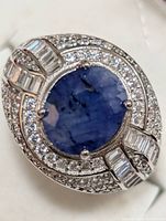 Close-up front view of the ring showing oval sapphire center stone and surrounding accent stones