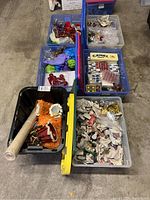 Overview of multiple plastic bins with Christmas decorations and wrapping paper.