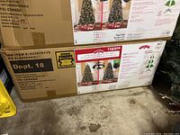 Box showing brand Holiday Time and product details including 7.5 ft Norwich Spruce artificial tree, pre-lit, made in China.