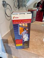 Box of Kidde Escape Ladder showing front and side with users demonstrating ladder use.