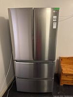 Front view of stainless steel LG refrigerator with French doors and two freezer drawers.