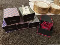 Six Neiman Marcus silk ties in individual gift boxes displayed on carpet