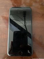 Front view of black iPhone SE 2020 powered off showing reflective screen and home button.