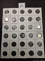 Full view of 30 Canadian commemorative quarters in individual holders arranged in a 6 by 5 grid on a white surface.