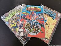 Photo of three 1980s DC Comics including Centurions #2, Conqueror of the Barren Earth #1, and Mister Miracle #7. Comics show wear from age and use.