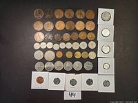 Overview of 50 assorted Great Britain coins from 1890 to 2010, showing variety of denominations and conditions on black background