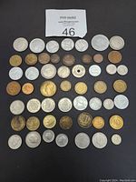 Top down photo of all 52 European coins arranged in rows on black background, showing diverse designs and metals.