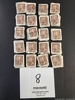 Close up photo of 24 individual 1935 Canada 2 cent stamps from Scott Catalogue #212, showing details of cancellation marks and condition variation.