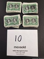 Clusters of green 1939 Canadian 1 cent stamps featuring King George VI and Queen Elizabeth with cancellation marks and perforated edges, showing condition variations.