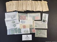Overview of small translucent envelopes each containing multiple used Canadian stamps, some envelopes marked with numbers like 15L, 20, 5, and 11.