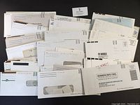 Multiple standard business envelopes sealed with stamps stored inside