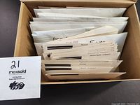 Box containing multiple envelopes filled with stamps, sorted by country.