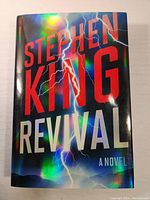 Front cover of the hardcover book with holographic dust jacket showing the title 'Stephen King Revival A Novel'