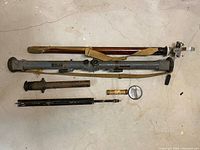 Photo showing rangefinder main unit, wooden case, tripod and additional optical accessories arranged on floor