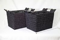 Two black woven rectangular baskets placed side by side on a white background, showing front and side views with handles visible.