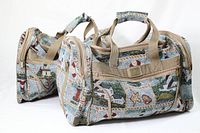 Two embroidered duffel bags with lighthouse and coastal scenes in beige color handles and trim, shown from a front-side angle