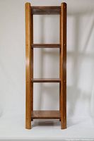 Front view of the 4-level solid wood shelf showing the vertical frame and four shelves.
