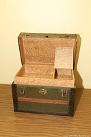 Small antique trunk with open lid, showing insert tray inside with two compartments and pink patterned lining.