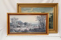 Two framed landscape paintings shown together, one in gold and red frame, the other gold frame, measuring about 14.5"x24.5" and 20"x27" respectively.