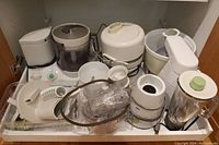 Full view of all Braun CombiMax 650 appliances and components arranged on a shelf, showing mixer base, blender, juicer and multiple attachments.