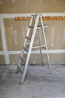 Full view of 6ft aluminum Featherlite step ladder in garage showing all six steps and rubber feet.