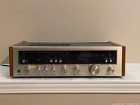 Front view of Kenwood KR-5600 AM-FM stereo receiver showing tuning scale, control knobs, and wood side panels.