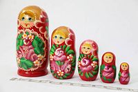 Front view of the five Matryoshka dolls lined up in descending size order with a ruler for scale
