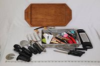Full view of the wood platter and various kitchen utensils laid out, showing the wide assortment.