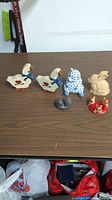 All seven animal figurines displayed on a wood grain surface showing the entire collection