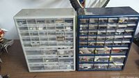 Two large hardware organizers placed side by side, filled with assorted small hardware in clear front drawers.