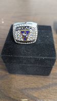 Front face of KCAC lacrosse championship ring with clear stones and blue/yellow logo