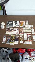 Overview of the lot on a brown table including signed baseballs, signed photos, ticket stubs, and trading cards
