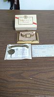 Full lot displaying vintage Bulova watch in gold frame holder, original Bulova box, guarantee bond, and registration form.
