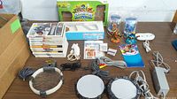 Full lot showing all games, accessories, controllers, and figures arranged on table.