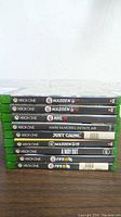 Photo showing nine Xbox One game titles stacked horizontally, including Madden 17, NHL 19, FIFA 18, and others.