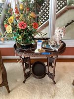Overall view of the Asian wooden folding tray table with decorative items on top including flower arrangement, rotary phone, and white cat clock.