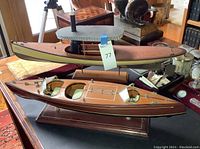 Both wooden boat models displayed side by side on table showing overall lot