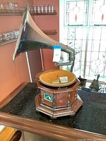 Front three-quarter view showing wooden cabinet, velvet turntable and metal horn