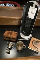 Wide shot of all six items together: heater, box, cups, album and keychain.