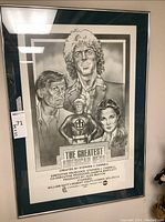 Framed black-and-white promotional poster showing main cast portraits, surrounded by green mat and silver-tone frame