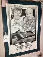 Framed poster showing illustrated portraits of the two main characters and a sports car