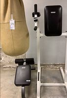 Photo showing the heavy bag hanging and fitness equipment beside it, including Roman armchair and incline bench, all tagged.