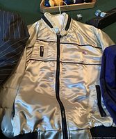 Front view of silver satin bomber jacket showing zip closure and front pocket